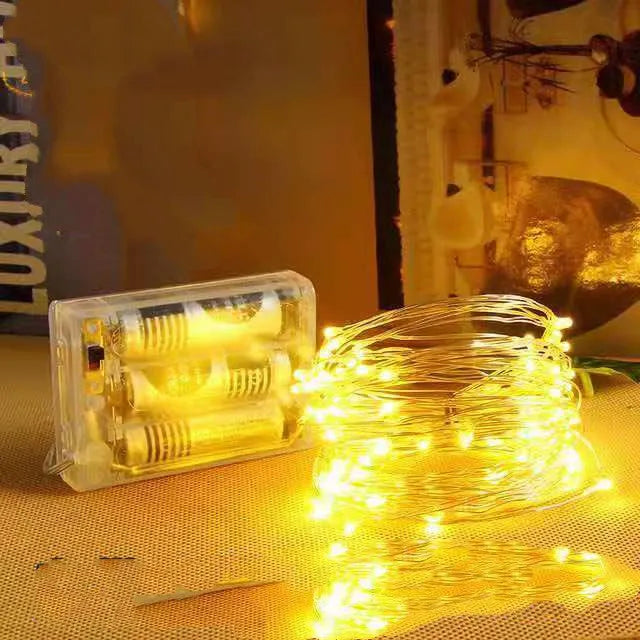 12-metre long copper wire LED string lights with small bulbs, connected to a white battery box controller.