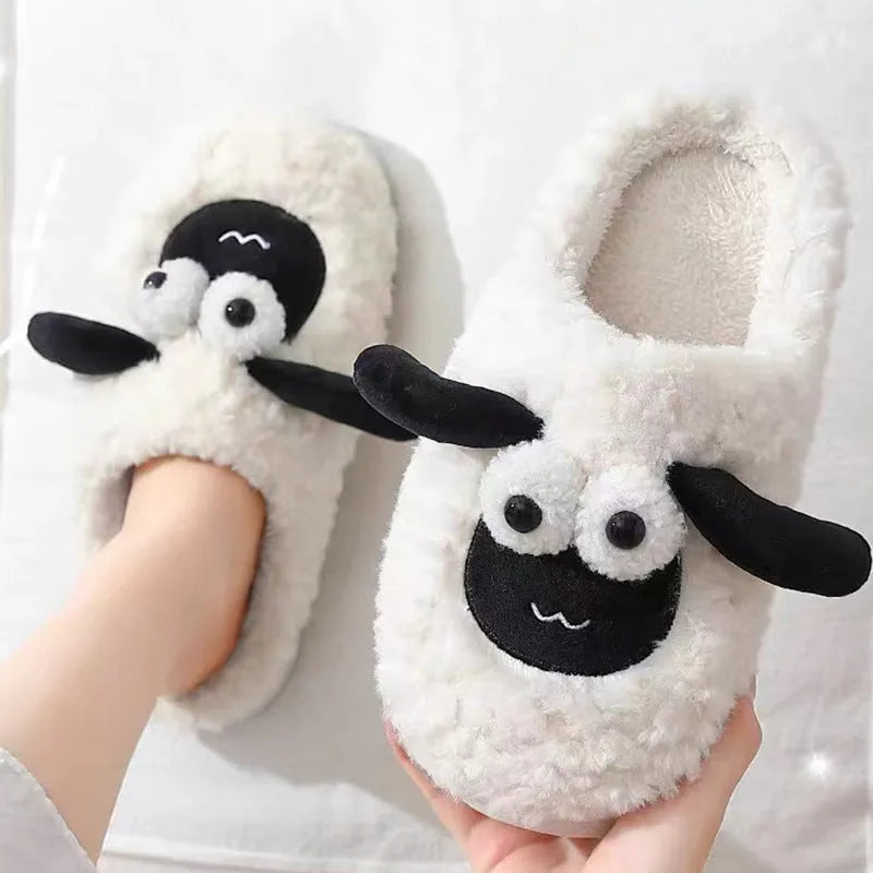 Brown suede slip-on slippers with a light-coloured sewn PVC sole on a wooden floor.