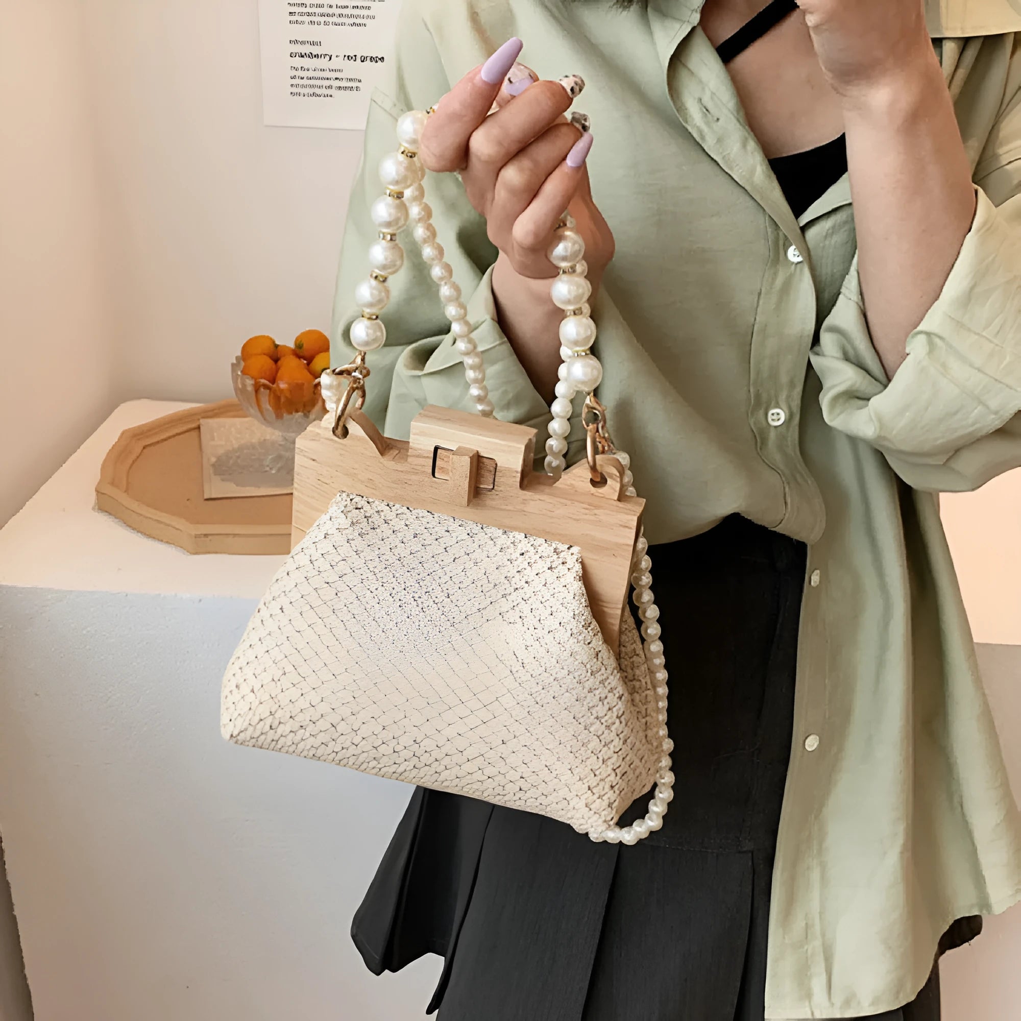 Women's straw shoulder bag with pearl chain detail and multiple zipper compartments in neutral colour