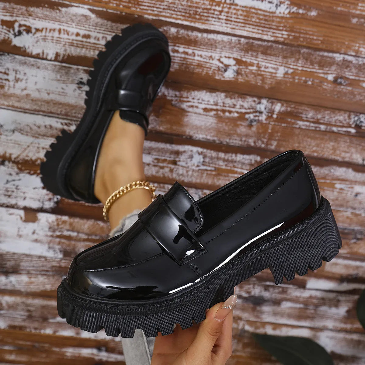 Women's plus size black slip-on loafers with a chunky platform heel and rubber sole.