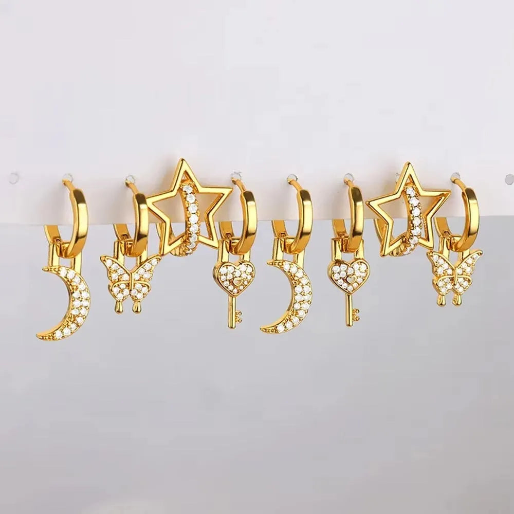 A pair of women's geometric butterfly earrings made from copper with heart, bow, and star shapes in a gold colour finish.