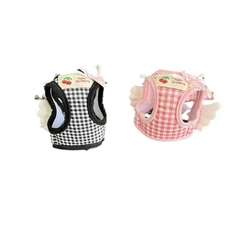 Small dog wearing pink cotton chest and back harness with hand holding rope attachment