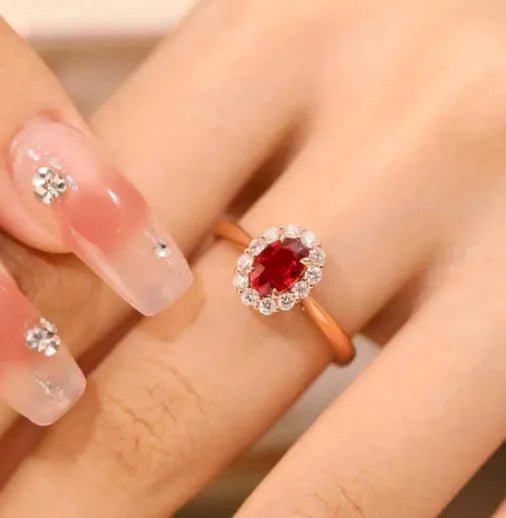 Women's silver ring with gold pigeon design and large red gemstone inlay on a floral pattern band.