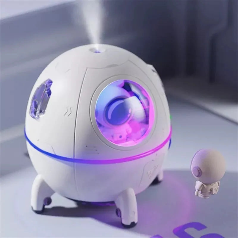 Purple astronaut-shaped USB desktop humidifier with LED lights on a desk