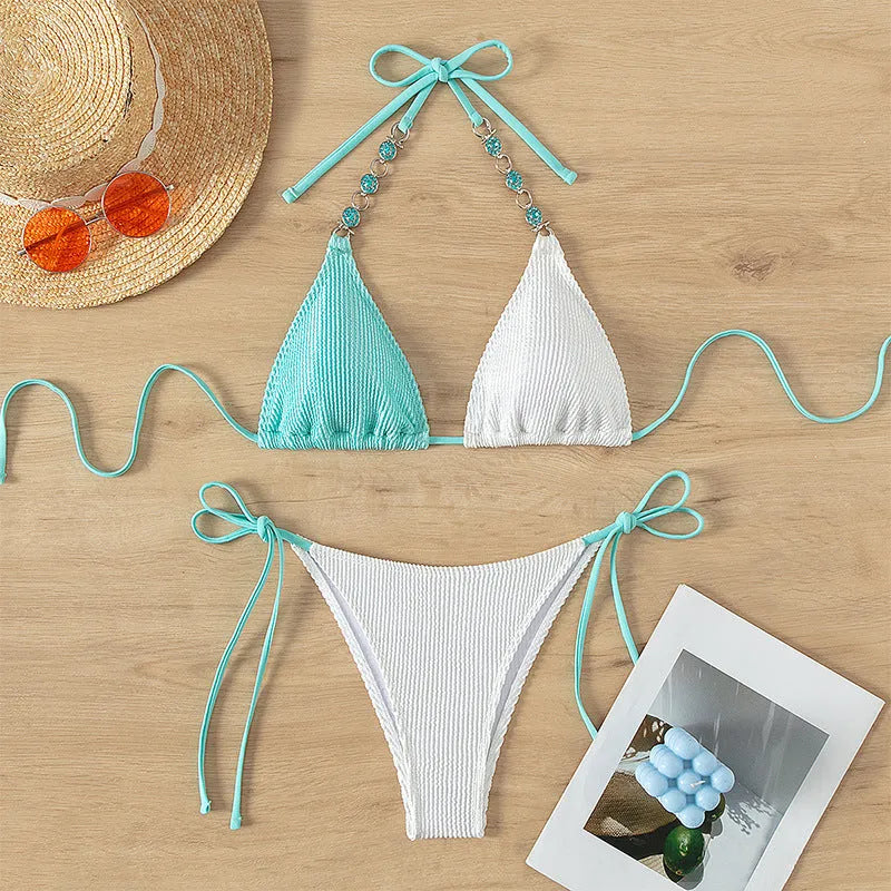 Women's colour-matching nylon swimsuit set with lace-up top, pearl chain, and shorts.