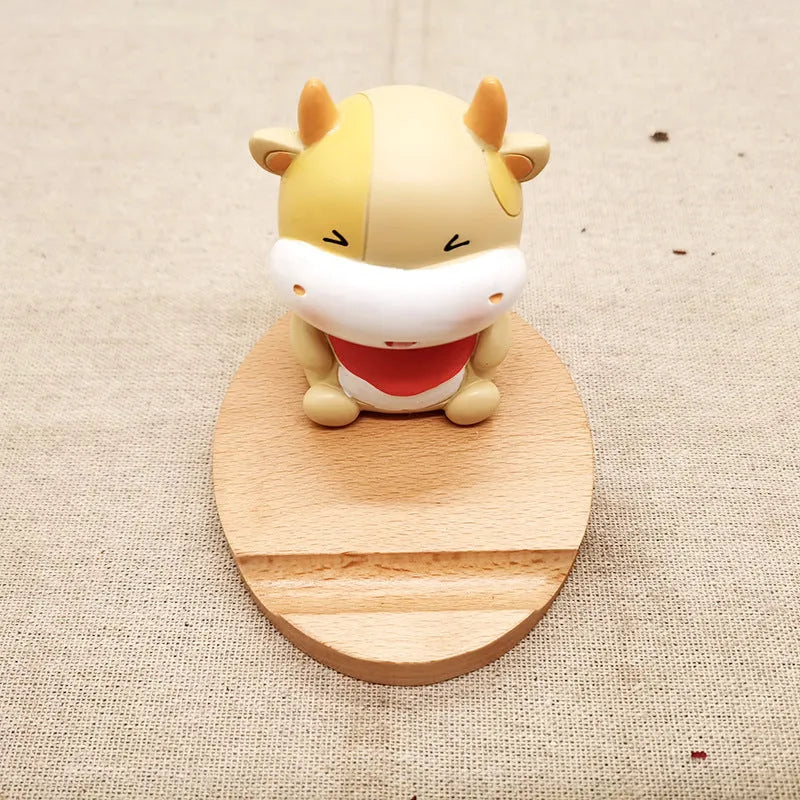 Solid beech wood mobile phone stand with a decorative resin animal ornament and a coin slot.