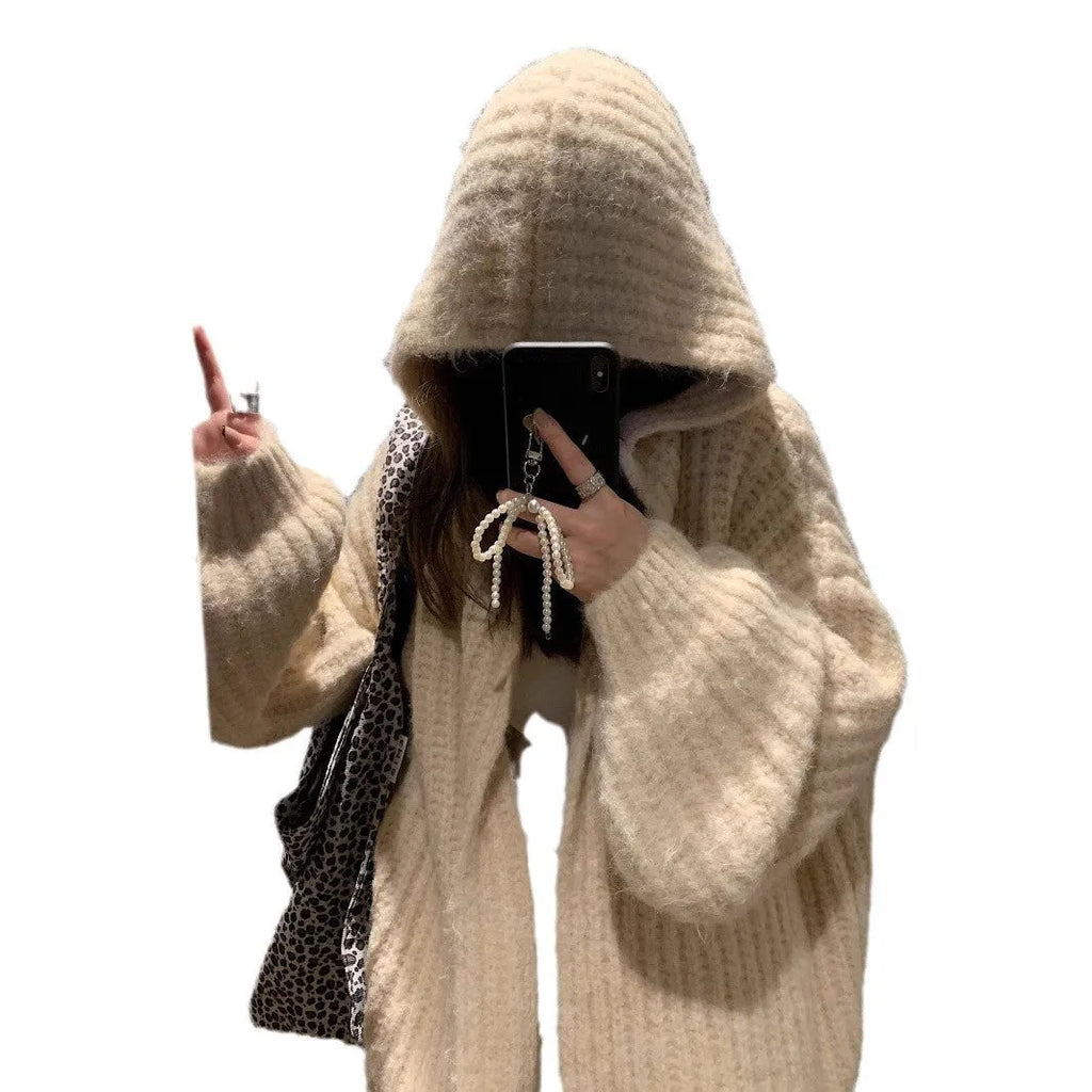 Women's retro-style thick knitted hooded cardigan in dark grey, shown open over a top.