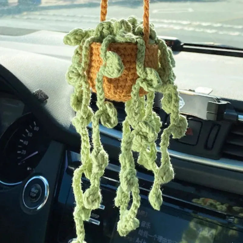 Green and white knitted wool car plant decoration basket with white hanging cord.