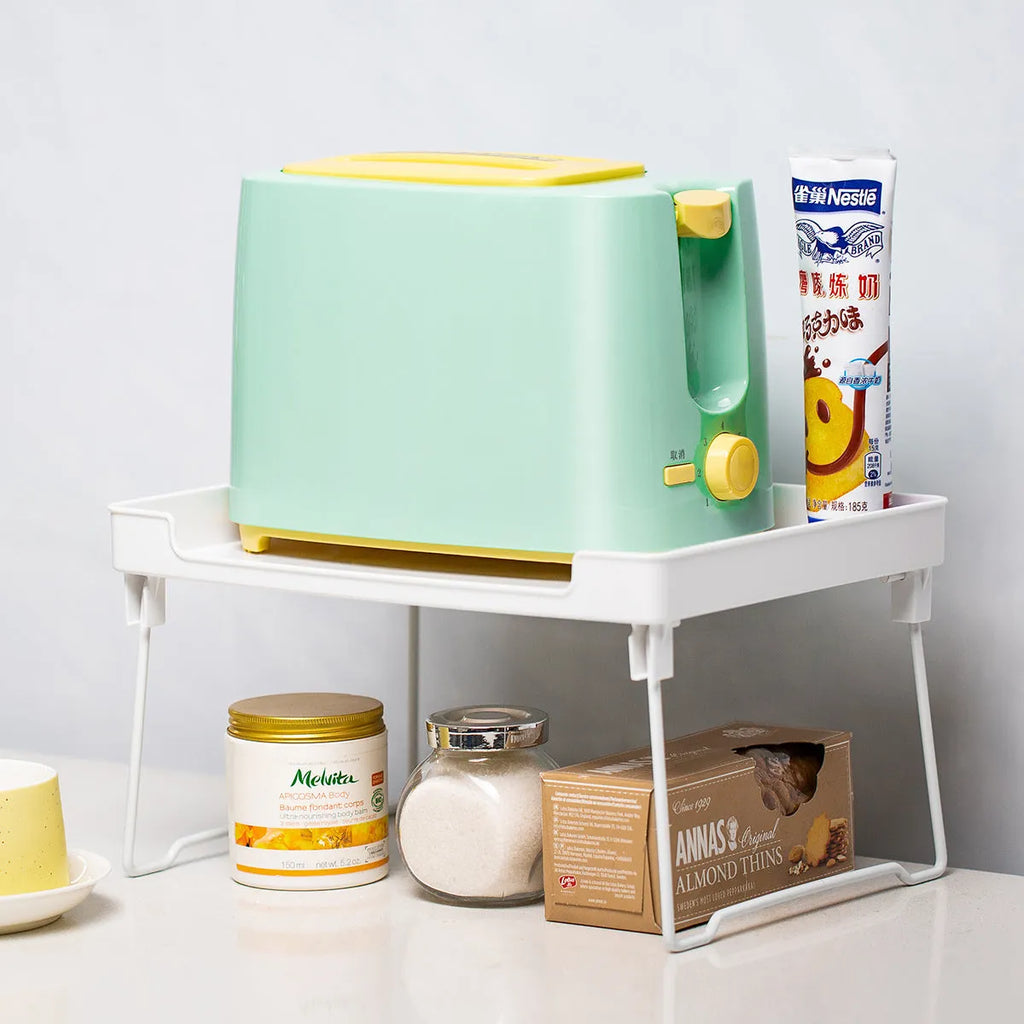 White and transparent plastic kitchen shelf organiser for countertop or cupboard storage.