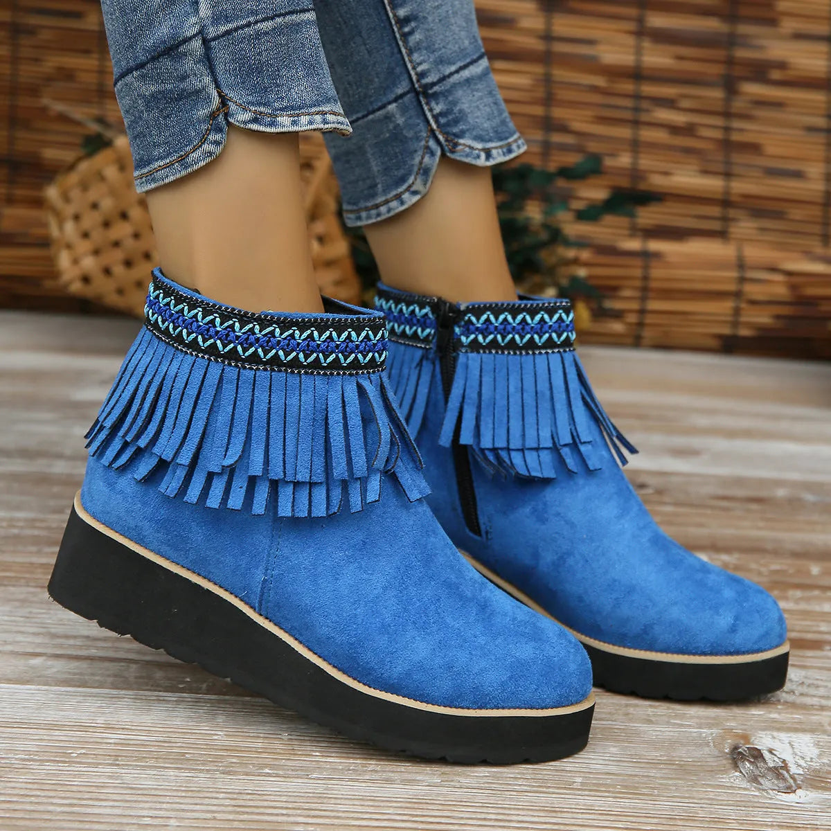 Women's black suede wedge ankle boot with side zip, tassel, and thick rubber sole.