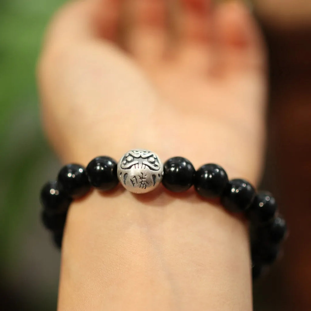 Close-up of a black agate and sterling silver bracelet showing 10mm beads and detailed clasp.