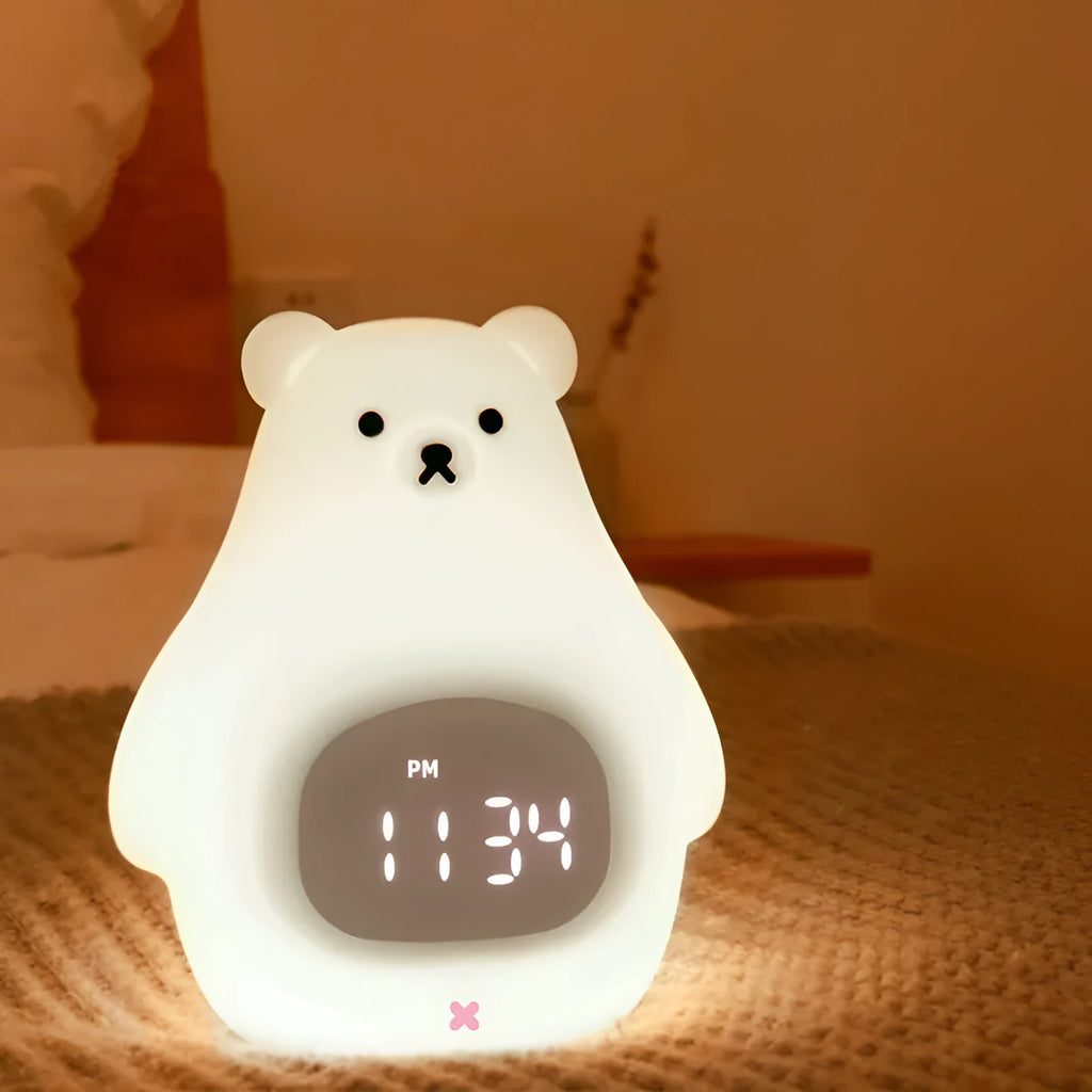 White cartoon bear silicone night light with remote control on a bedside table.