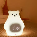 White cartoon bear silicone night light with remote control on a bedside table.