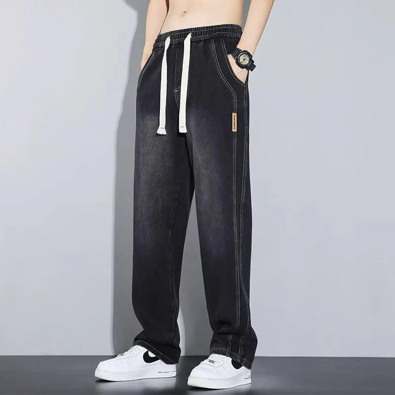 Men's loose fit straight leg cotton denim jeans with elastic waist and rope closure, available in four colours