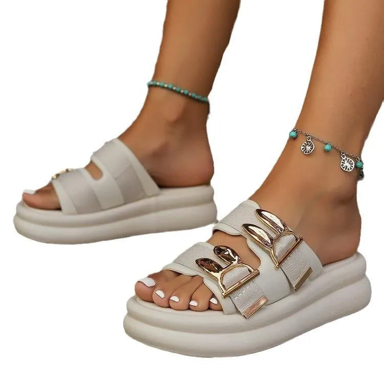 Women's apricot suede slippers with a thick, soft rubber sole on a wooden floor.