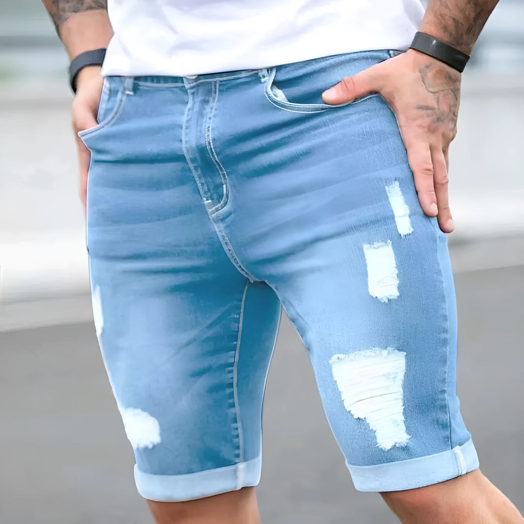 Men's sky blue denim shorts with multi-hole distressed design showing low waist and straight cut