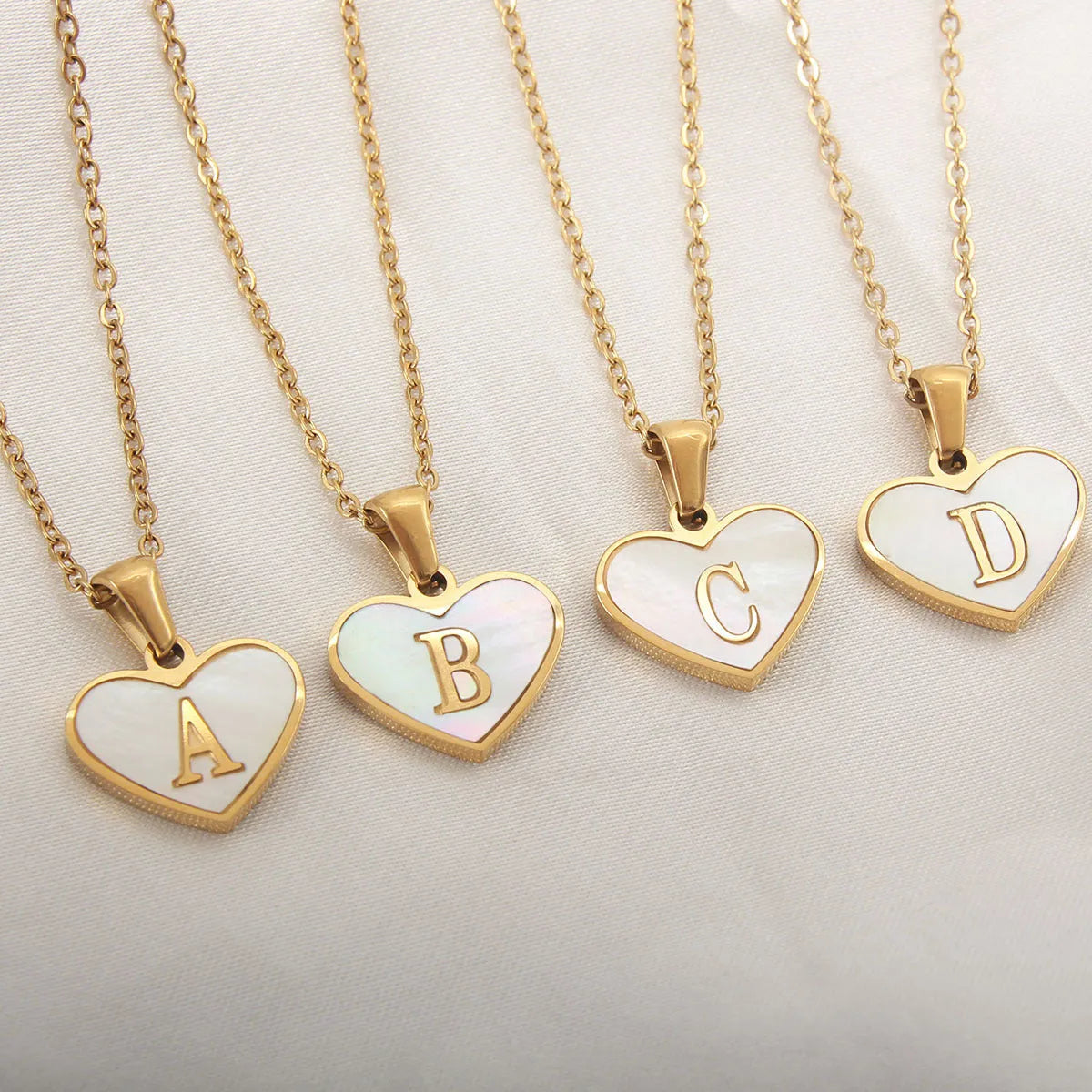 Gold-plated stainless steel necklace with a letter pendant and heart charm on a 45+5cm chain.