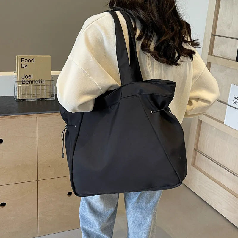 Soft Oxford cloth folding tote bag shown in a choice of five colours on a plain background.