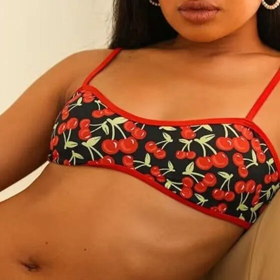 Women's cherry blossom print tube top bikini swimsuit set on a neutral background.