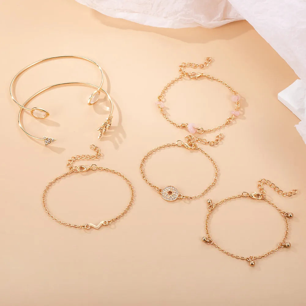 Set of six gold-coloured women's bracelets with arrow, water drop, and V-shaped pendants.