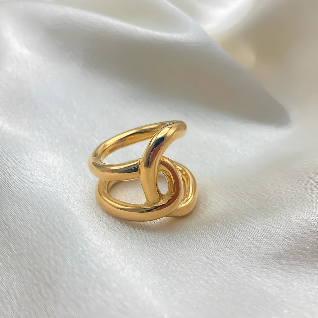 Geometric knotted U-shaped adjustable ring in stainless steel, shown in gold tone and steel colour.