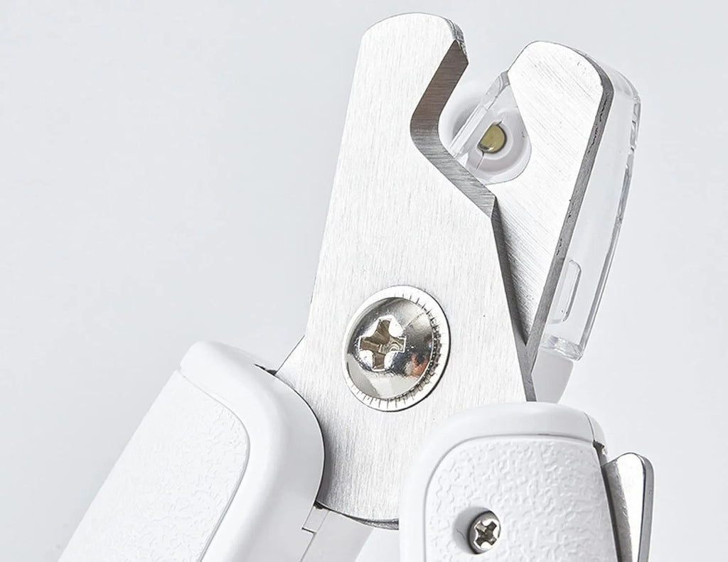 White LED pet nail clipper with transparent anti-splash guard open, showing triangular stainless steel blade