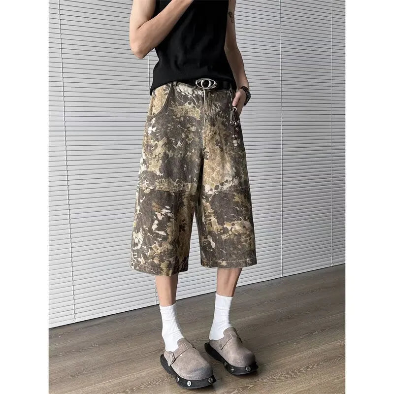 Men's yellow denim jeans with a snake pattern and camouflage tooling print, showing cropped leg length.