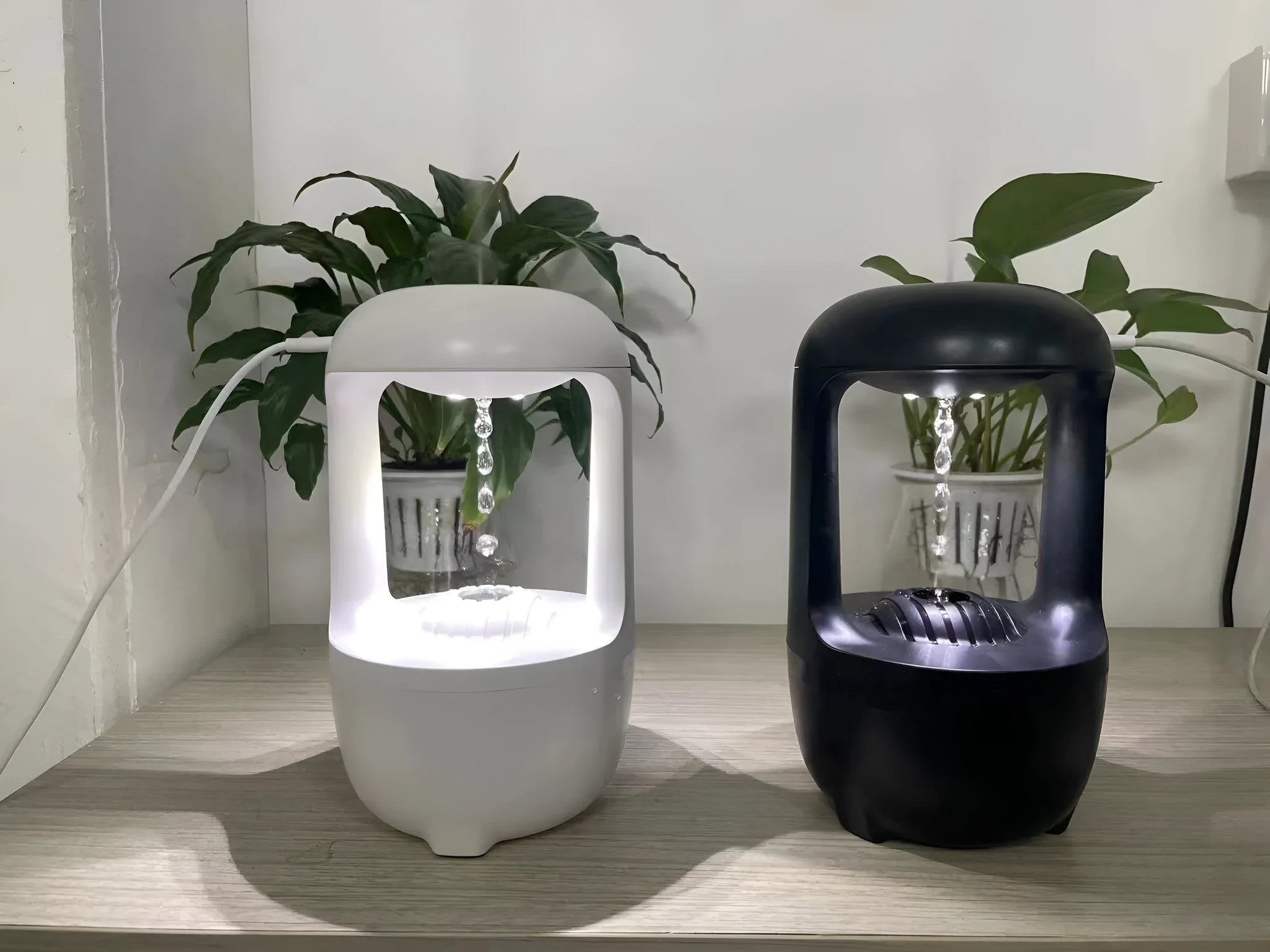 White anti-gravity humidifier with upward-flowing water droplets on a desk