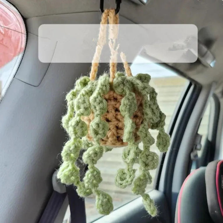 Green and white knitted wool car plant decoration basket with white hanging cord.