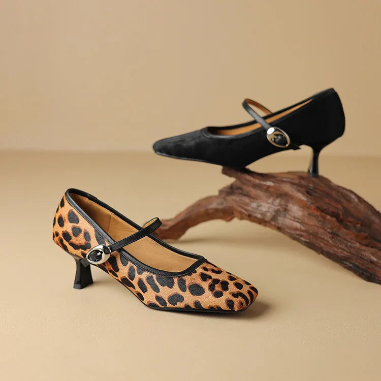 Women's black square toe ankle-strap stiletto heels with horse hair upper on wooden surface