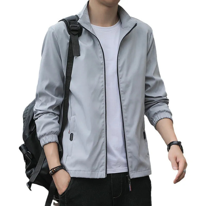 Man wearing a loose-fit black Korean-style autumn jacket with a lapel collar and zipper pockets.