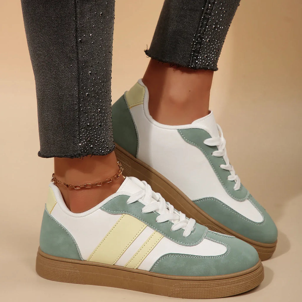 Green women's retro sports pumps with cross straps and leather stitching details