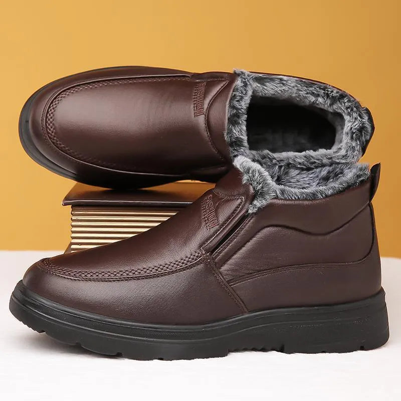 Men's black fleece-lined slip-on winter shoes with a rubber sole on a grey background.