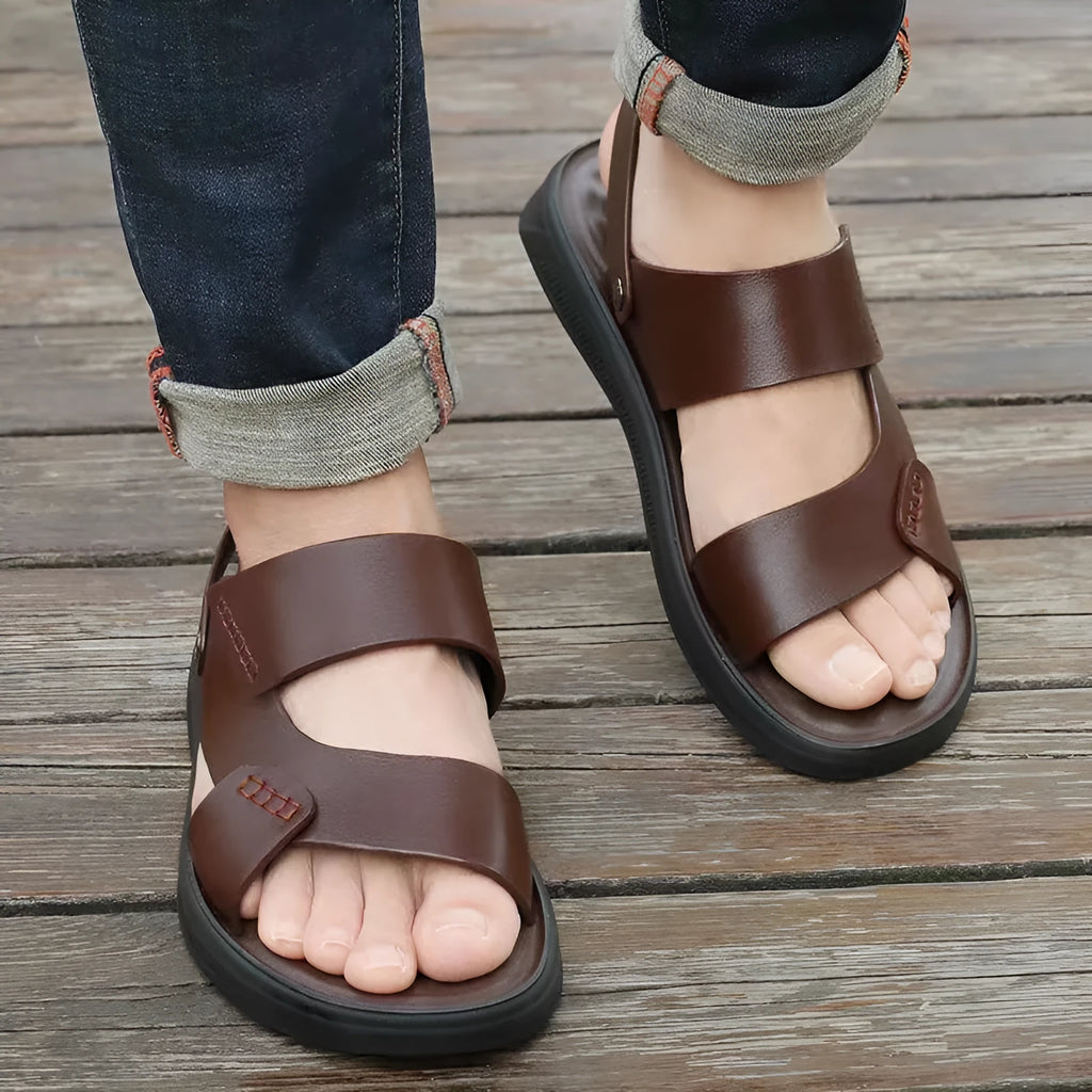 Men's brown and black waterproof plastic casual sandals on a beach background.