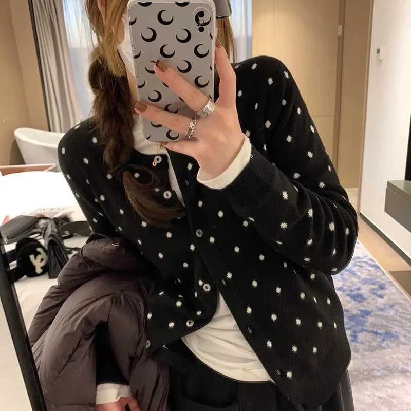 Women's loose fit grey dot knitted cardigan with crocheted flower trim on long sleeves.