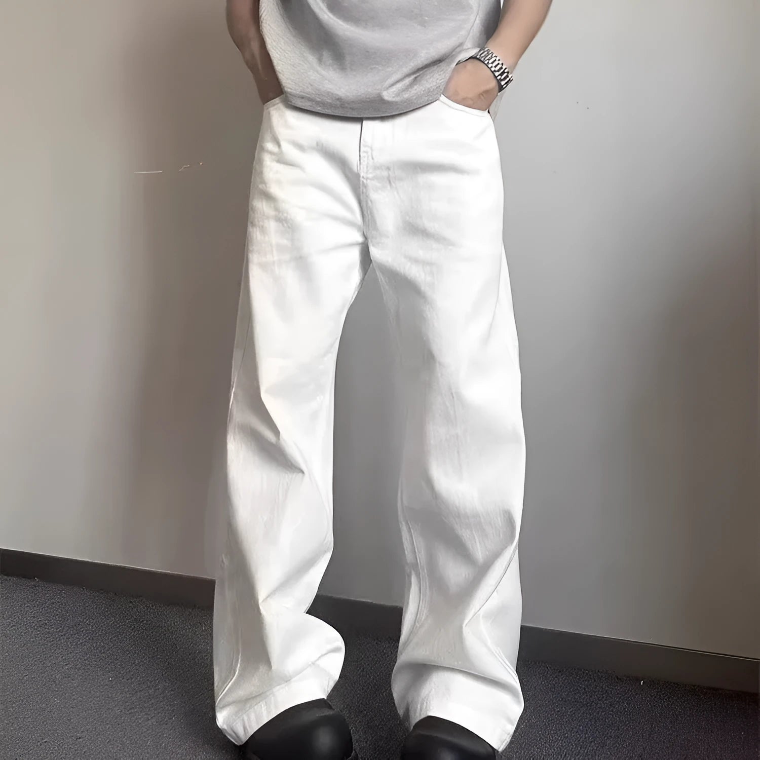 Men's white straight-leg denim jeans on a neutral background, showing mid waist and loose fit.