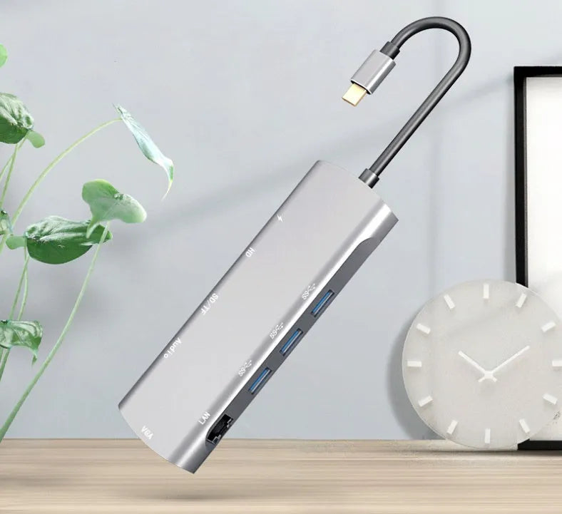 Grey aluminium USB-C docking station with HDMI, VGA, and USB 3.0 ports.