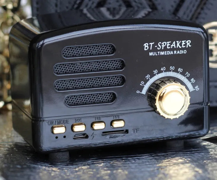 Compact vintage style Bluetooth speaker in wood grain finish on a wooden table