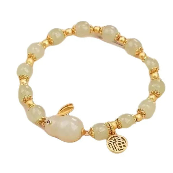 Women's black bracelet with a green jade hare charm, fu character symbol and lily motif design.