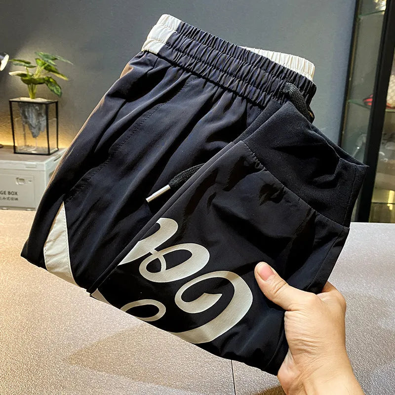 Black men's cropped trousers with banded ankle made from ice silk and cotton fabric.