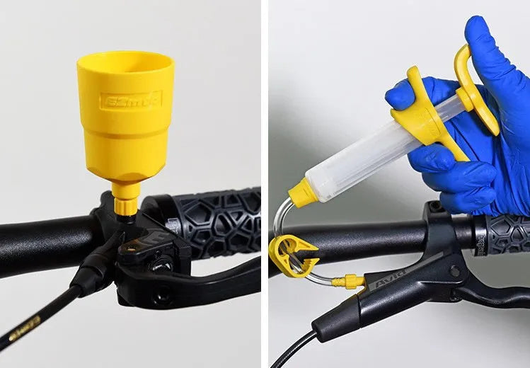 EZmtb bicycle hydraulic brake bleed kit showing syringes, metal fittings, adapters, and tools on a workbench.