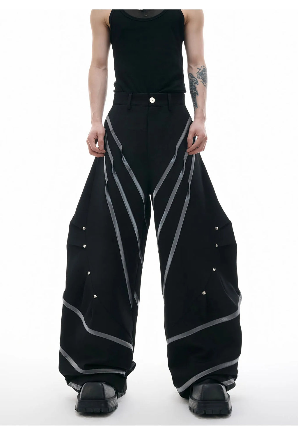 Men's black trousers with silver metal striped rivet details and pleated front.