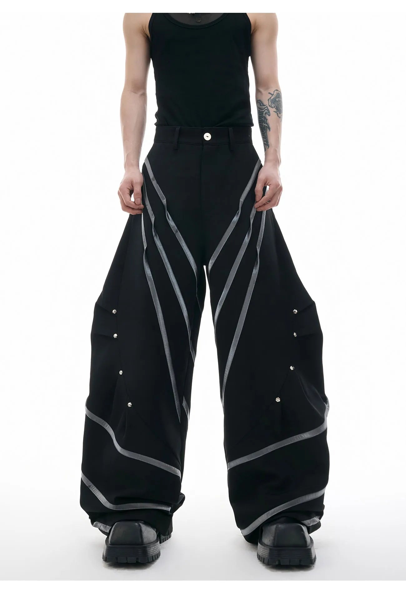 Men's black trousers with silver metal striped rivet details and pleated front.