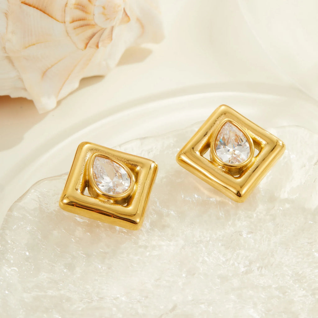 Gold coloured geometric stud earrings with an inlaid water drop zircon stone.