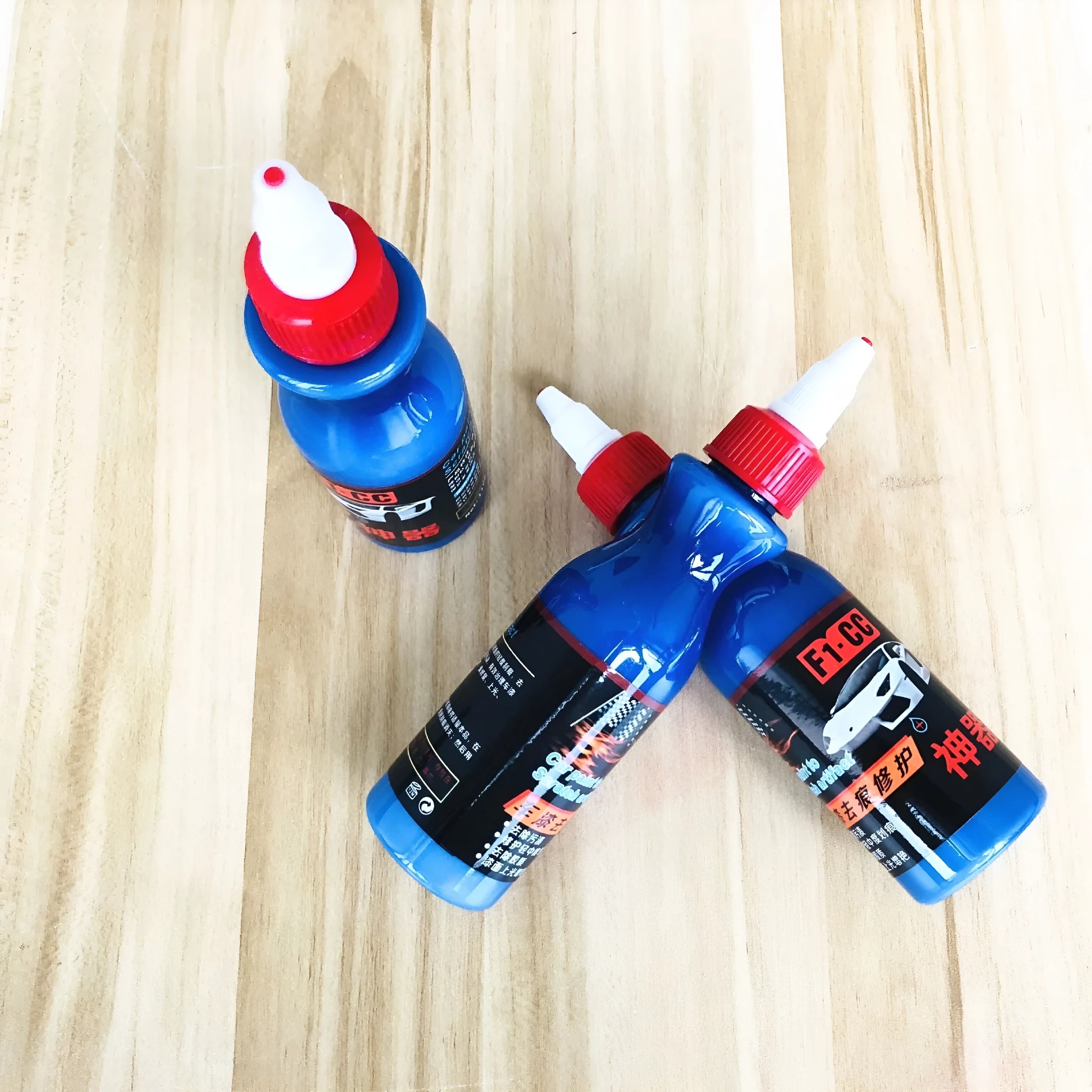 Small blue car scratch repair applicator tool with wiping sponge and repair agent bottle