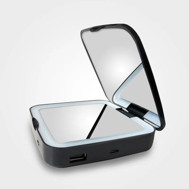 Black and white makeup mirror with dual magnification surfaces and adjustable lighting controls
