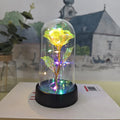 Small glass night lamp with plastic flowers on a black base.