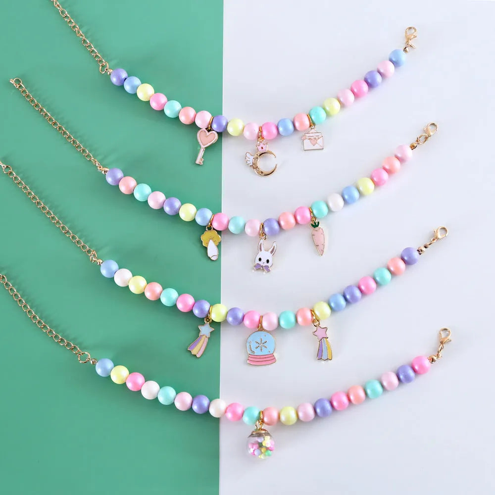 Colourful macaron-themed resin pet collar and matching bracelet set on a table.