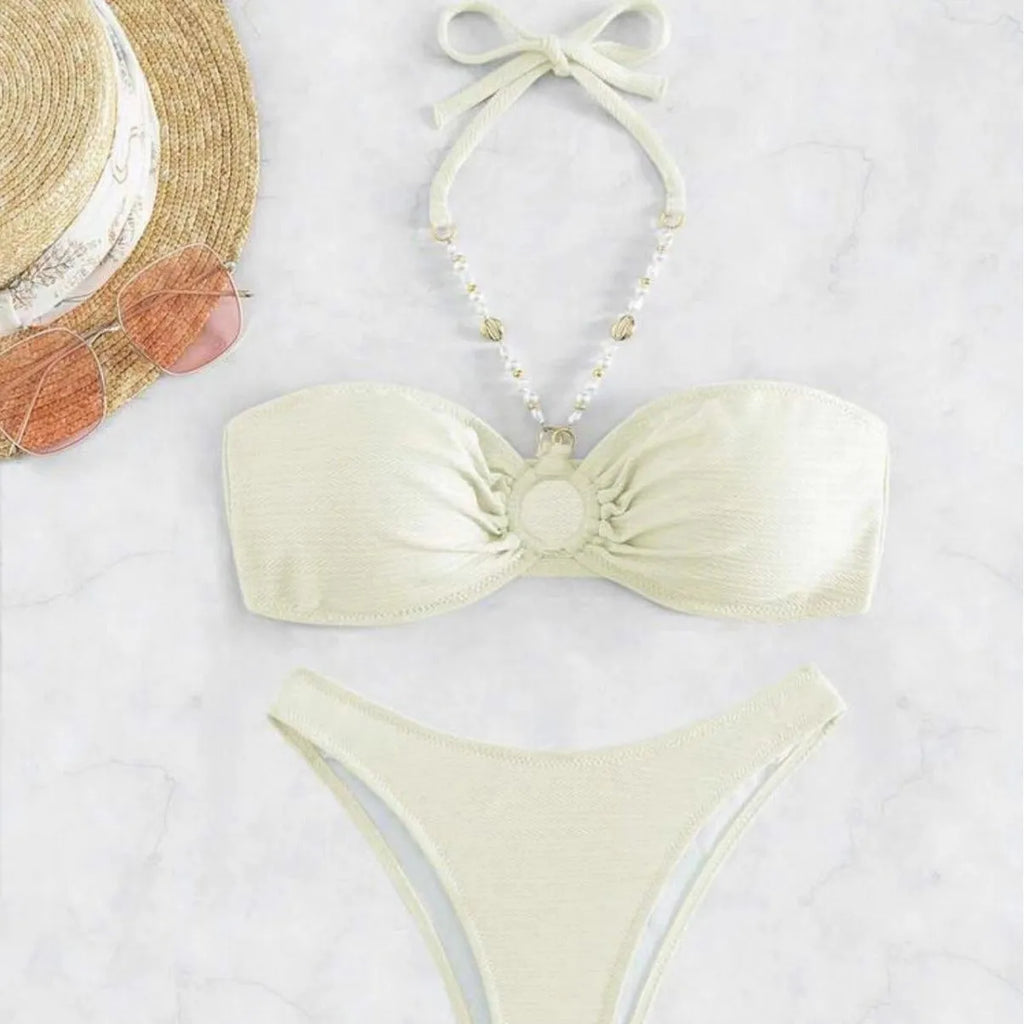 Women's halter-neck bikini swimwear set in a solid colour, shown on a model.