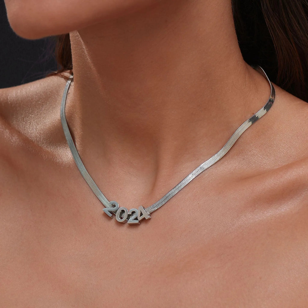 A gold and a silver titanium steel necklace with letter and number pendants on a 40.5cm chain.